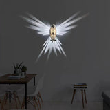 Decorative wall light shaped like a bird with spread wings in a room setting.