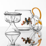 Clear glass tea set with floral design on a white background