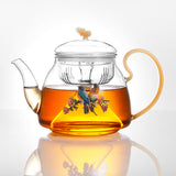 Glass teapot with floral design on a white background