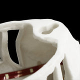 Close-up of a white ceramic object with a dark interior on a black background