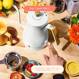 White electric kettle on a wooden table with a hand pointing to it, surrounded by tea-making items.
