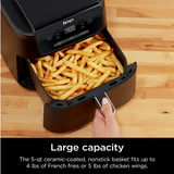 Ninja air fryer with a large capacity filled with French fries on a wooden surface.