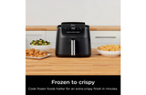 Ninja air fryer on a kitchen counter with food items around
