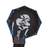 Umbrella with a stylized face design on a black background