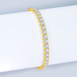 Gold bracelet with clear gemstones on a white surface